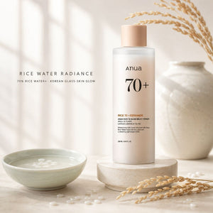 Anua 70+ Rice Water Radiance moisturizing toner in a frosted bottle with a beige cap, styled on a stone pedestal with a ceramic bowl, dried wheat, and a textured vase in the background.