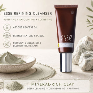 Esse Refining Cleanser in a dark brown squeeze tube with a silver cap, displayed on a light beige background with skincare props including a bowl of clay mask, powder, and rocks. Text highlights its purifying, exfoliating, and oil-absorbing properties.
