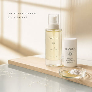 Epicutis Power Cleanse Oil + Enzyme set, featuring a clear bottle of oil cleanser and a white tube of enzyme exfoliating powder on a wooden tray, with a small glass dish of powder in front.