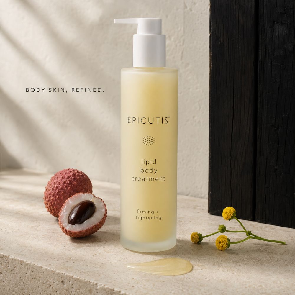 A bottle of EPICUTIS Lipid Body Treatment stands on a stone surface with lychee fruit and small yellow flowers beside it. The bottle is frosted with pale yellow liquid inside and has a white pump.