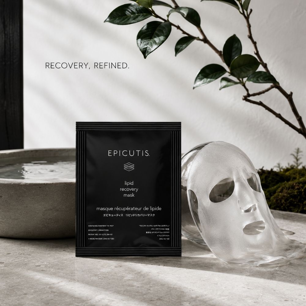 A single black EPICUTIS recovery mask packet stands on a stone surface beside a clear silicone face mask, with a white wall, leafy branch, and shallow water bowl in the background. The text 'RECOVERY, REFINED.