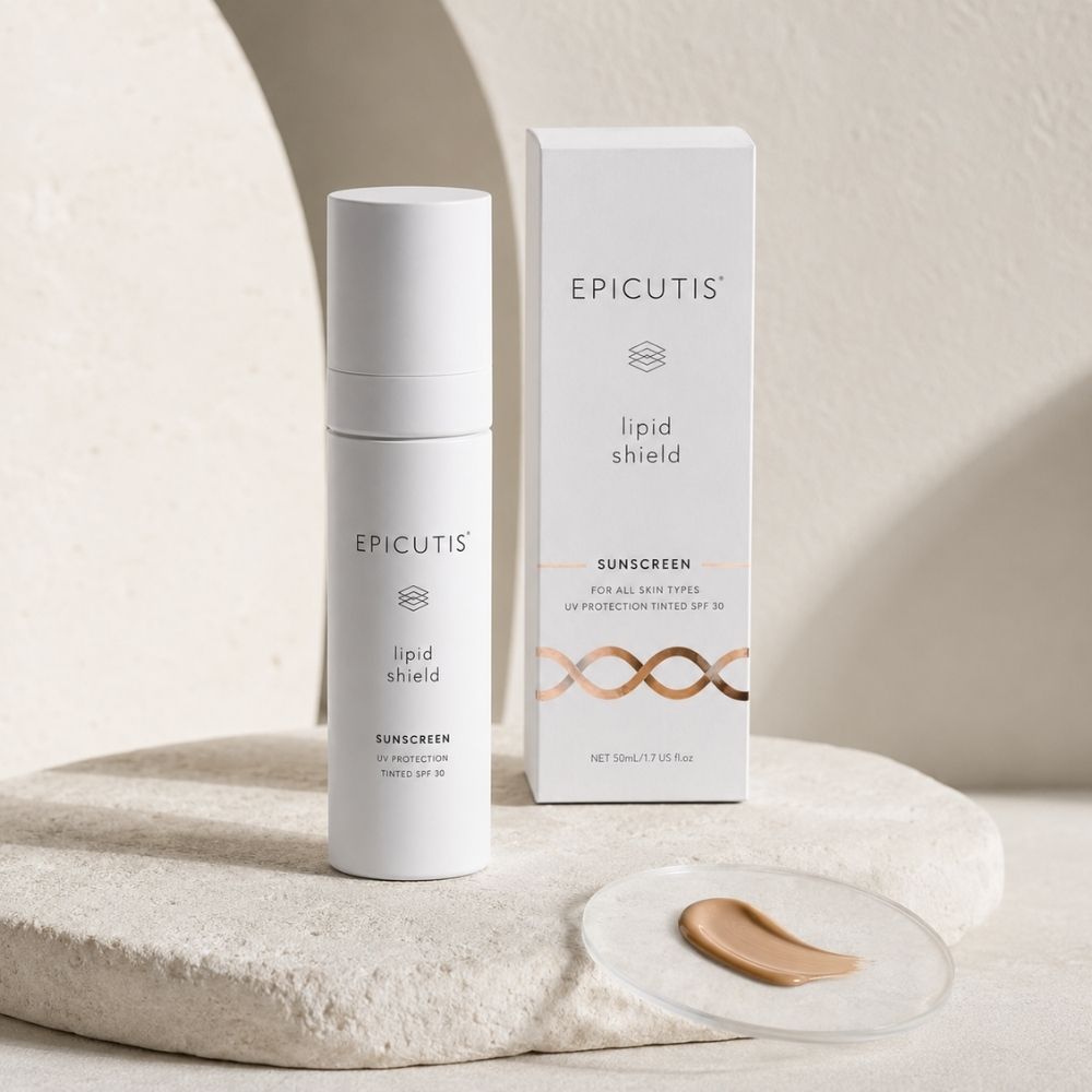 Epicutis Lipid Shield sunscreen bottle and box displayed on a textured stone surface with a small clear dish holding a beige sunscreen smear, in a warm neutral setting.