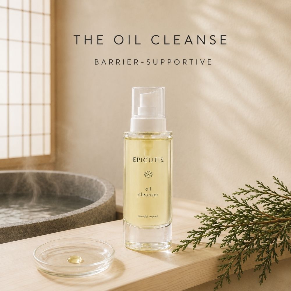 A bottle of EPICUTIS oil cleanser stands on a wooden surface beside a small dish of product, with a real spa-like setting including a stone basin, window light, and greenery. Text above reads 'THE OIL CLEANSE' and 'BARRIER-SUPPORTIVE'.