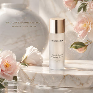 Miracletox Camellia Exosome Brightening Ampoule bottle with a metallic gold cap, displayed on a white marble pedestal with pink camelia flowers and a soft, bright background.