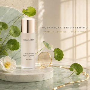 Miracletox Camellia Exosome Brightening Ampoule in a frosted white bottle with a metallic gold cap, styled on a marble pedestal with green centella leaves and a camelia flower against a warm beige background with text overlay.