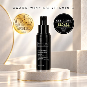 Revision Skincare C Correcting Complex 30% Vitamin C serum in a black pump bottle, displayed on a round marble pedestal with award badges and promotional text in the background.